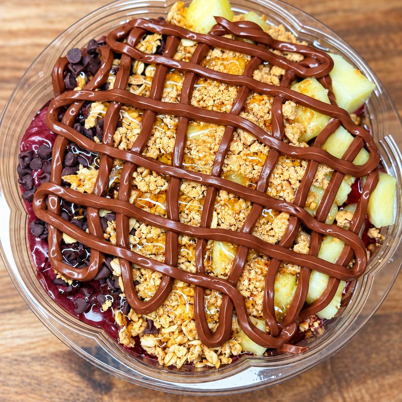 Açaí bowl with pineapple, chocolate chips, granola and a chocolate drizzle